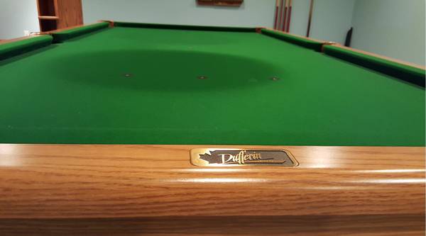 Close-up of Dufferin nameplate on wooden rail and green playing surface