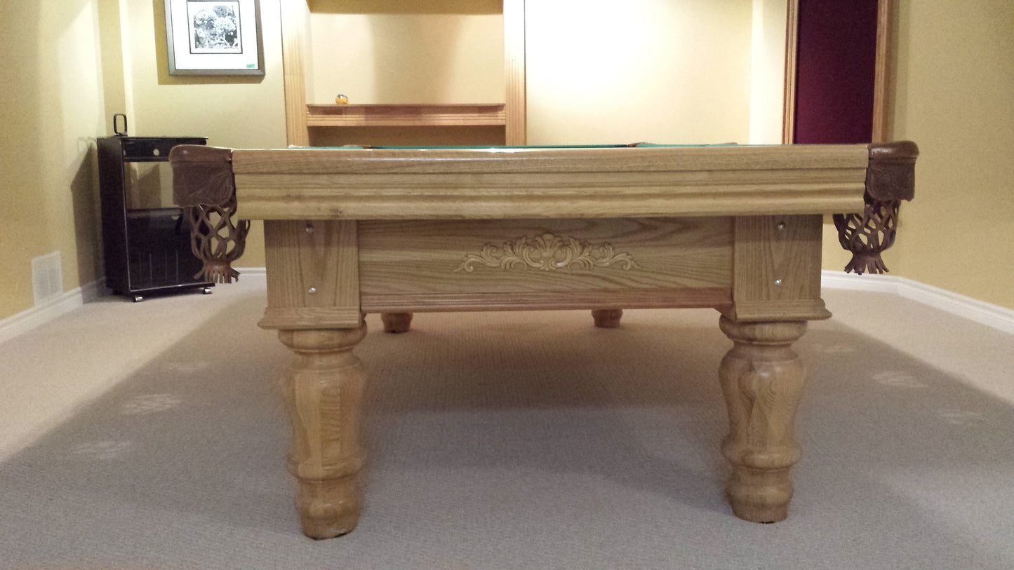 End view of billiard table showing carved wood rail and corner pocket