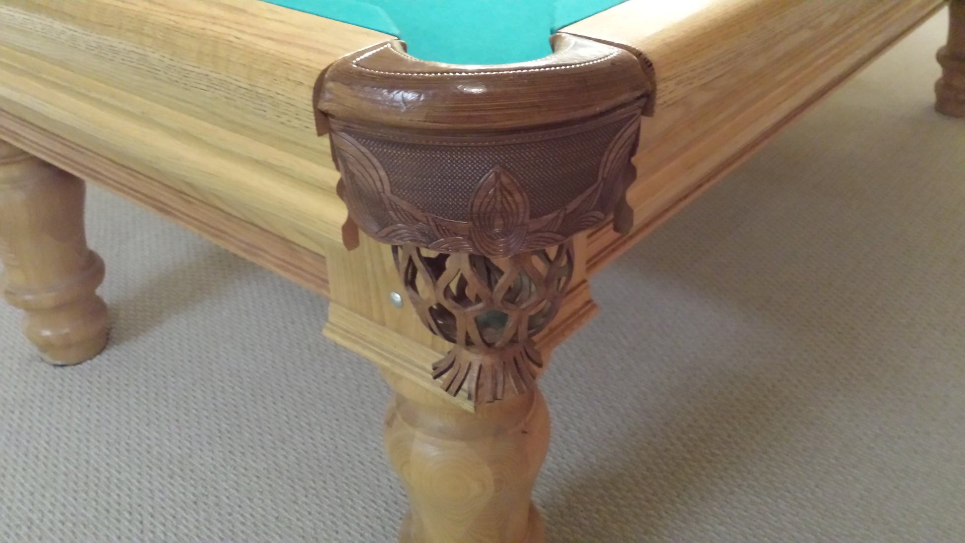 Close-up of corner pocket and carved wooden leg detail