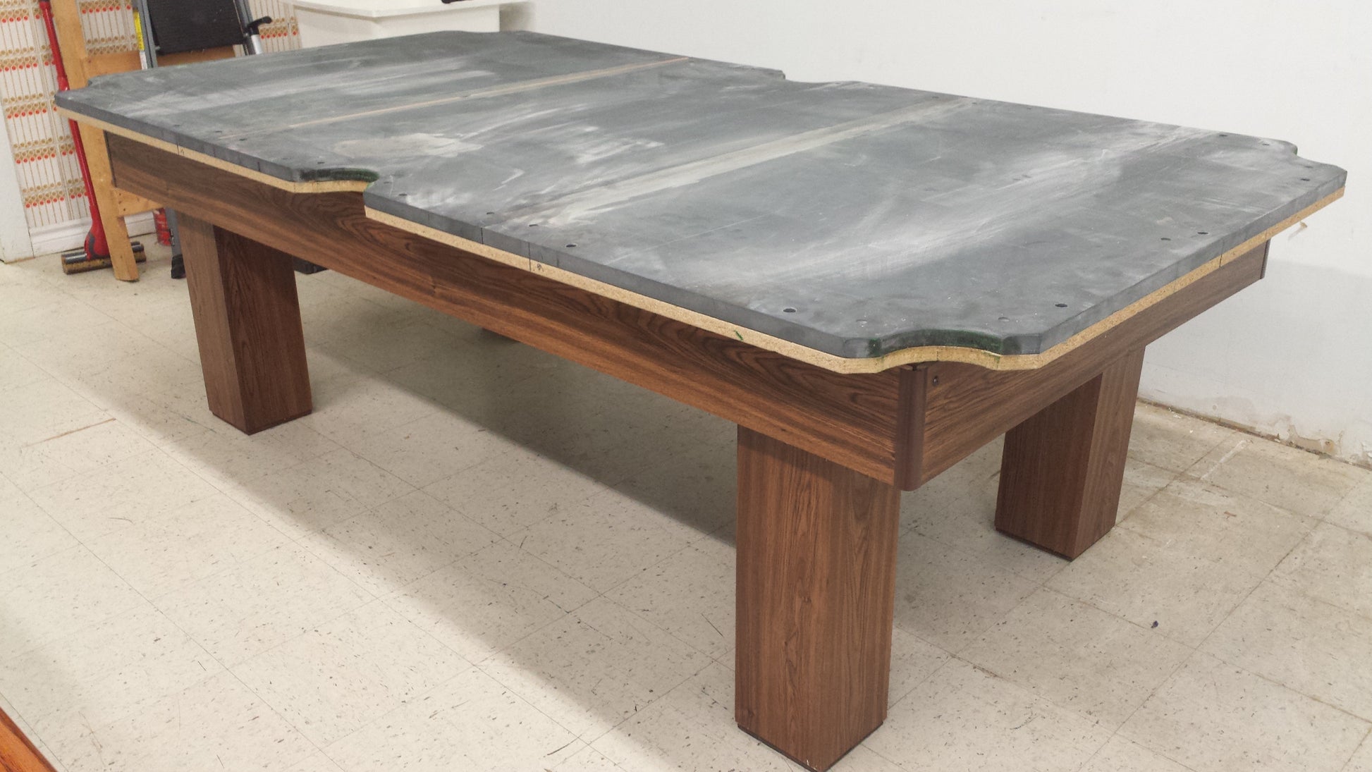 Slate playing surface installed on wooden pool table frame