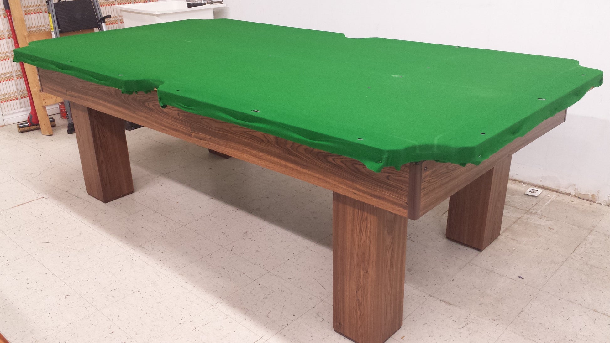 Completed pool table with bright green felt and corner pockets