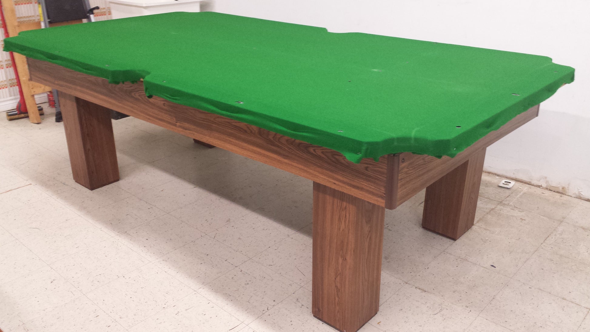 Angled view of 8-foot billiard table with green playing surface