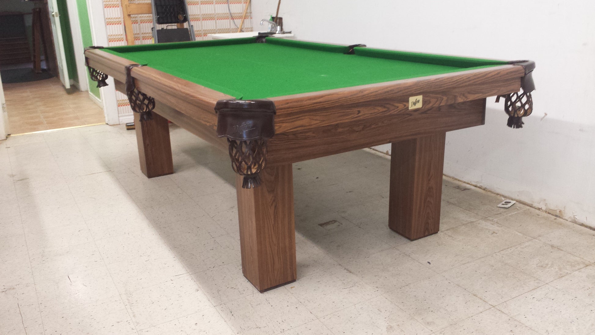 Close-up of corner pocket with ornamental leg carving visible