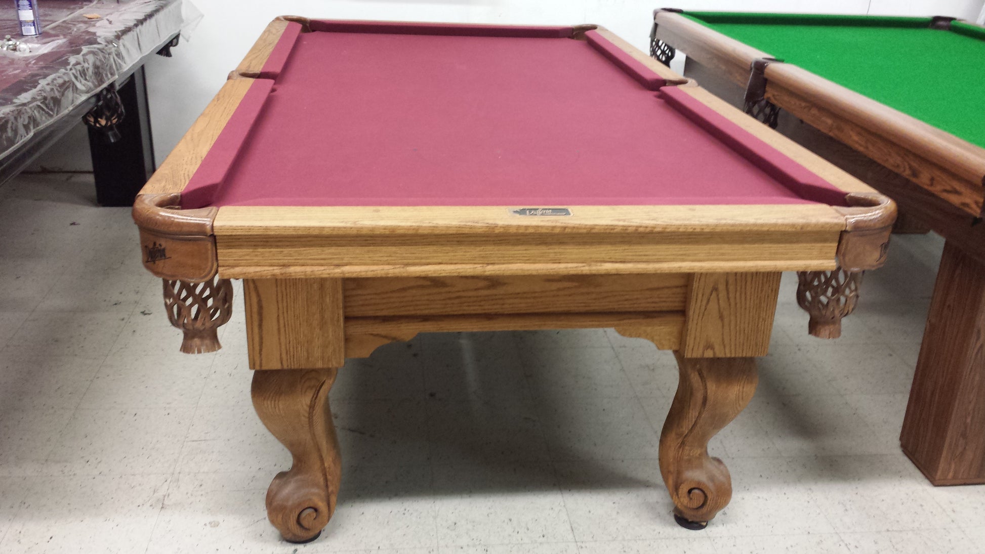 Angled view of preowned billiard table with ornate wood frame and claw feet