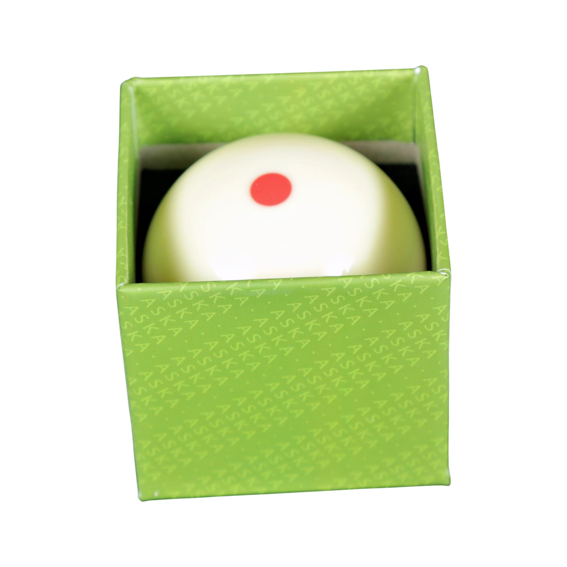 Close-up of a white billiard ball with a single red dot inside a green
