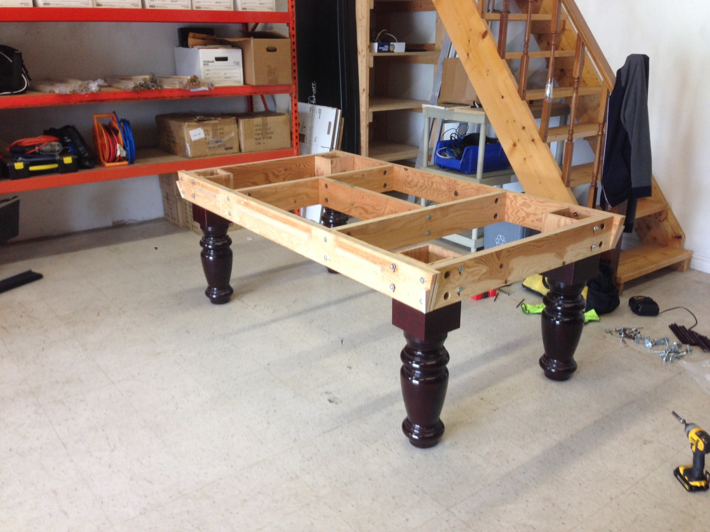 Wooden frame and slate bed construction with turned legs installed