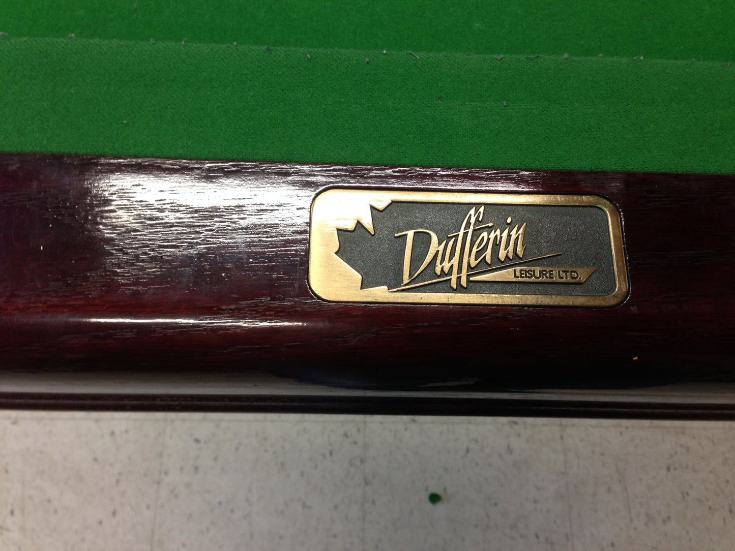 Close-up of Dufferin manufacturer's nameplate on table rail