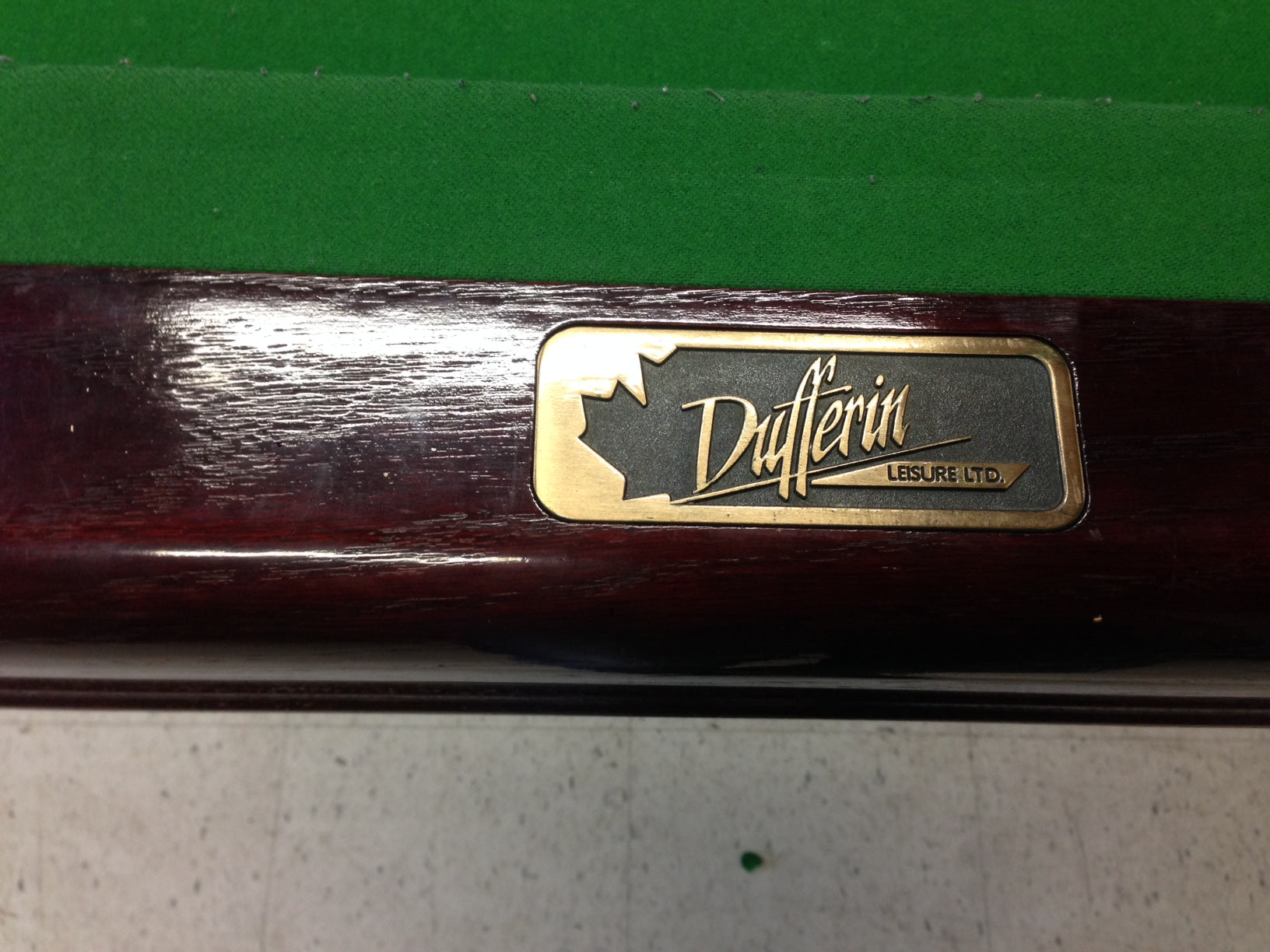 Close-up of Dufferin manufacturer's nameplate on table rail
