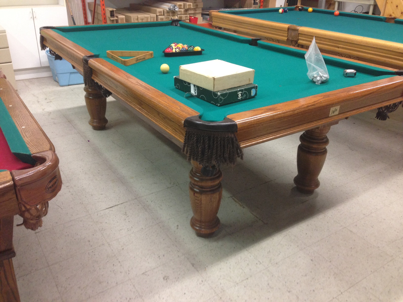 Angled view of billiard table showing turquoise playing surface and leg details
