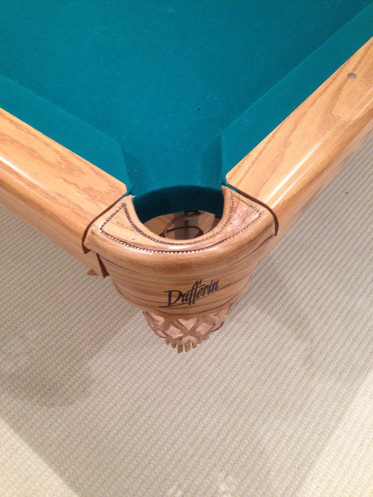 Overhead view of corner pocket opening and ornamental wood carvings