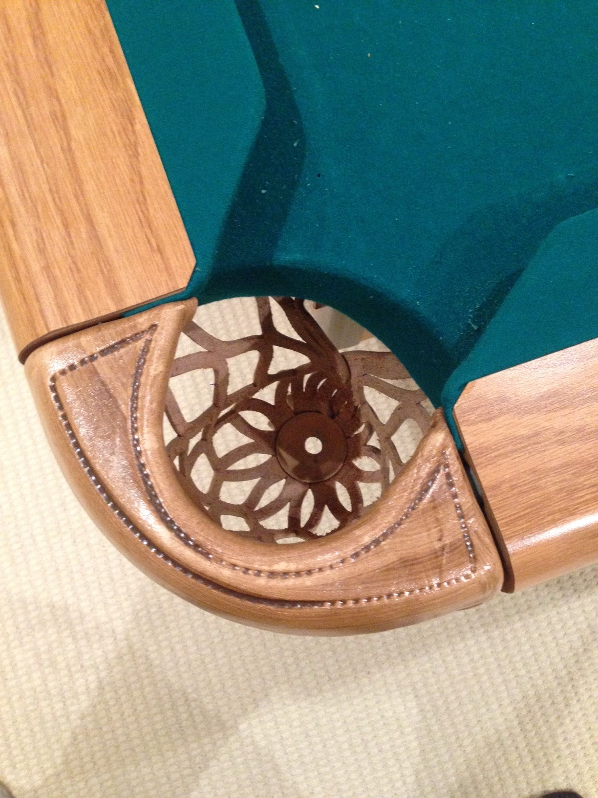 Corner pocket assembly with geometric lattice carving detail visible