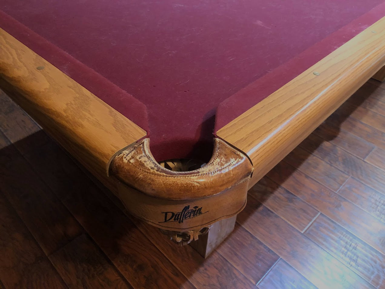 Corner pocket detail showing carved wood rail and Dufferin branding