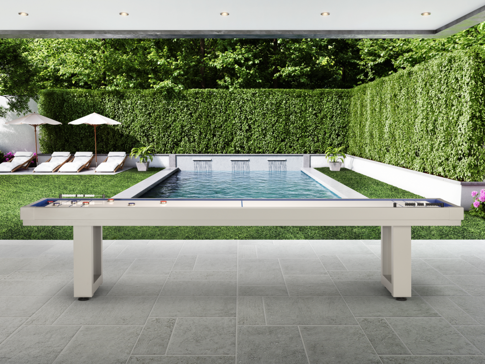 Shuffleboard table display in modern courtyard with hedge backdrop