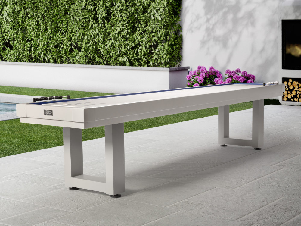 Pearl white shuffleboard table in outdoor patio setting with landscaping