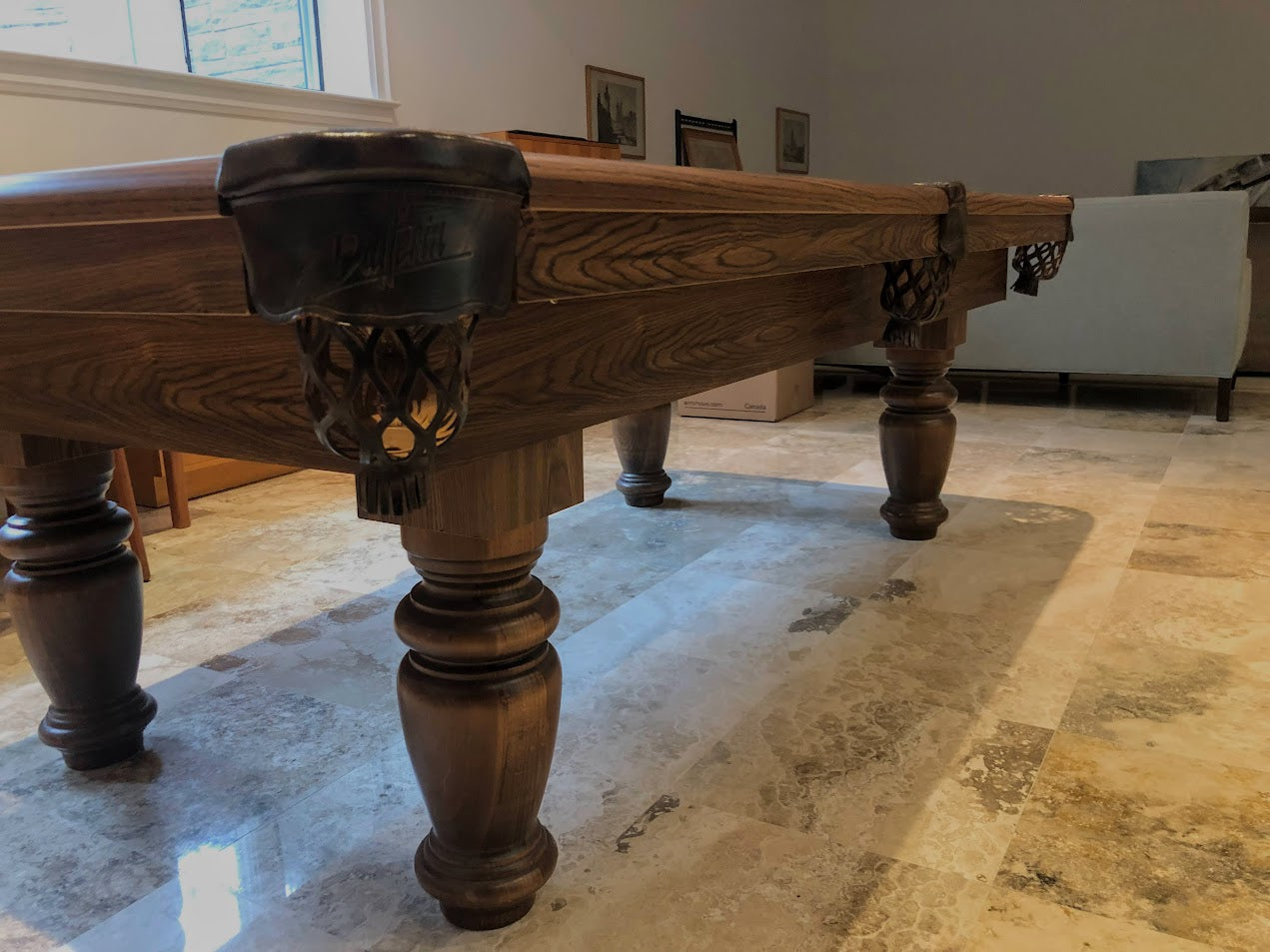 Detailed view of ornate leg base showing carved wood and black metal accents