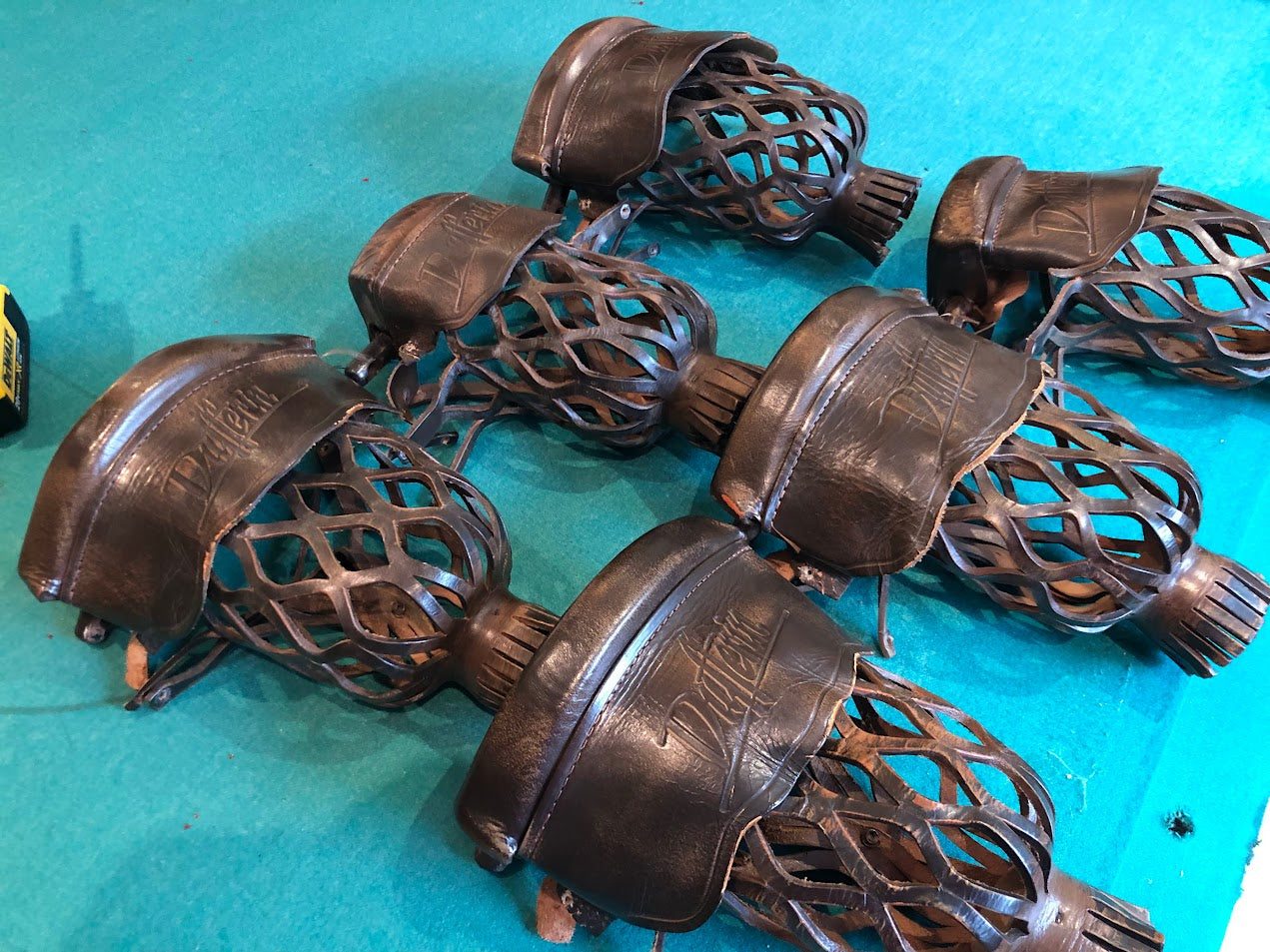 Leather pockets scattered on turquoise surface showing construction and wear patterns