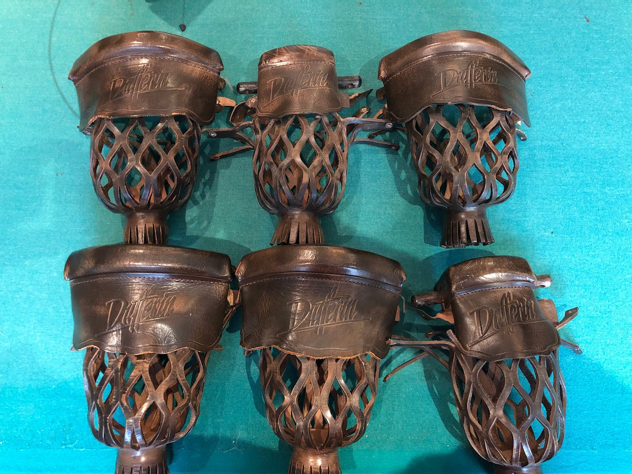 Six leather pockets displayed arranged in two rows showing decorative metal hardware