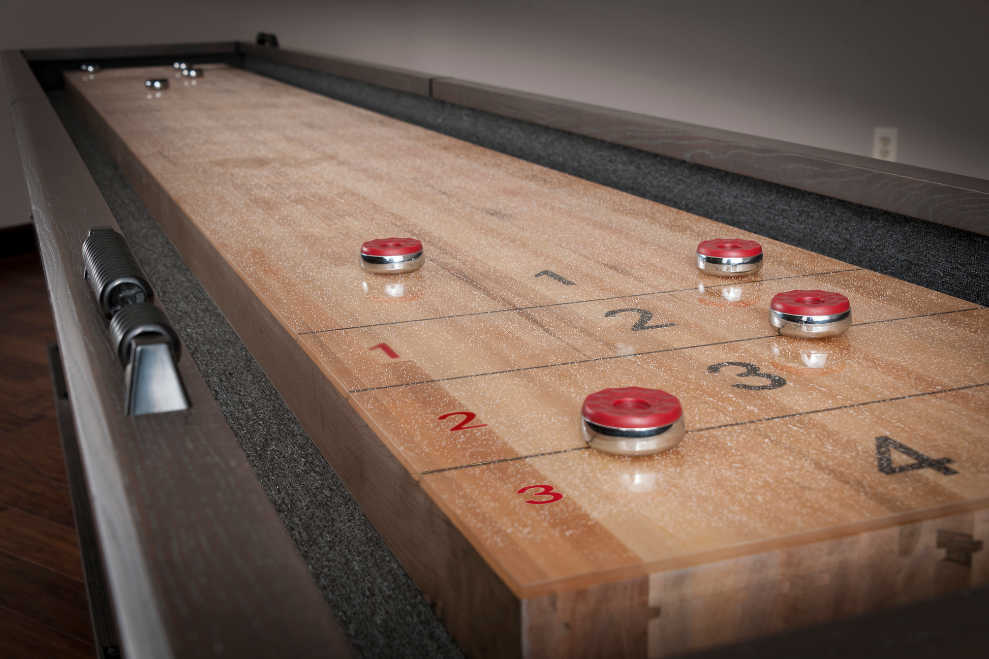 Angled view of shuffleboard court showing pucks and scoring lanes